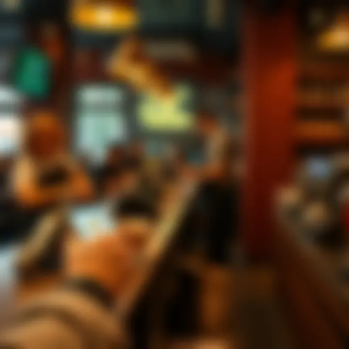 A person using a smartphone to pay with Bitcoin at a coffee shop counter while a barista prepares a drink.