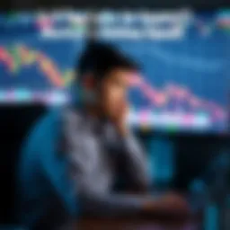 A person sits at a desk, looking puzzled at stock market charts on a computer screen with downward trends